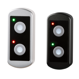 Two TG7 push-button housings: one natural aluminum color and one black anodized, each with two illuminated circular push-buttons and red and green status LEDs