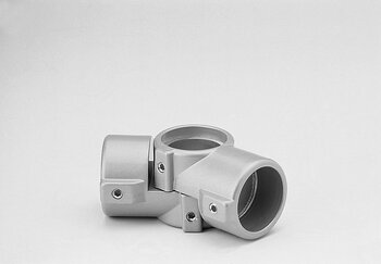 Silver metal four-way tube connector with cylindrical openings and screw fasteners on a plain background